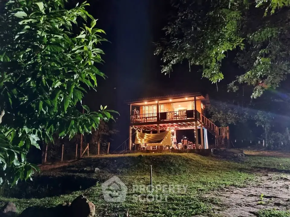 Charming rustic cabin with illuminated porch nestled in lush greenery, perfect for serene getaways.
