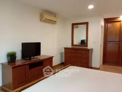 Spacious bedroom with wooden furniture and modern amenities