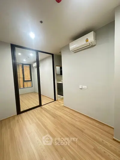 Modern bedroom with mirrored wardrobe and air conditioning in a stylish apartment