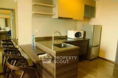Modern kitchen with sleek countertops and appliances in a stylish apartment.