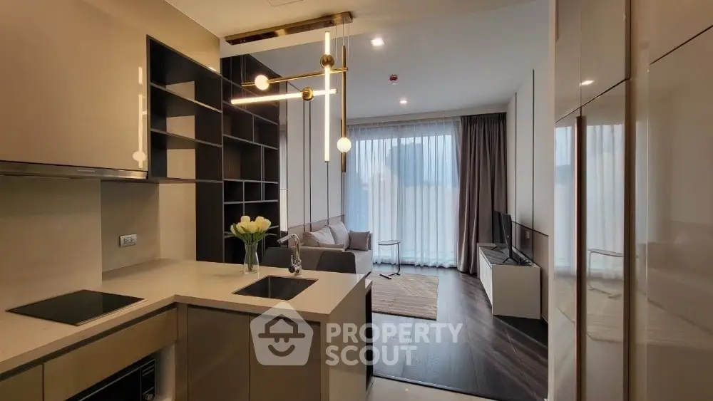 Modern open-plan kitchen and living room with stylish lighting and large windows