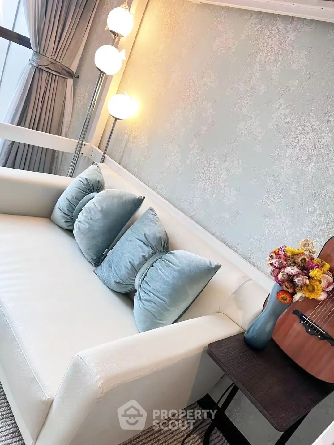 Chic living room with elegant sofa, stylish lighting, and decorative accents for modern comfort.