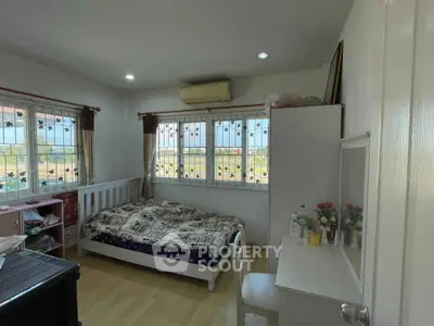 Cozy bedroom with natural light, featuring a single bed and desk, ideal for a serene living space.