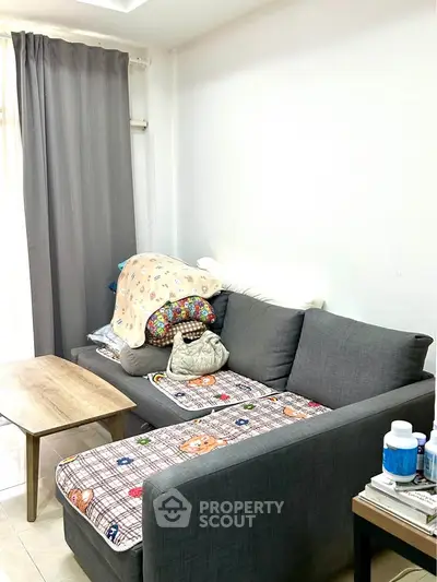 Cozy living room with modern gray sofa and wooden coffee table, perfect for relaxation.
