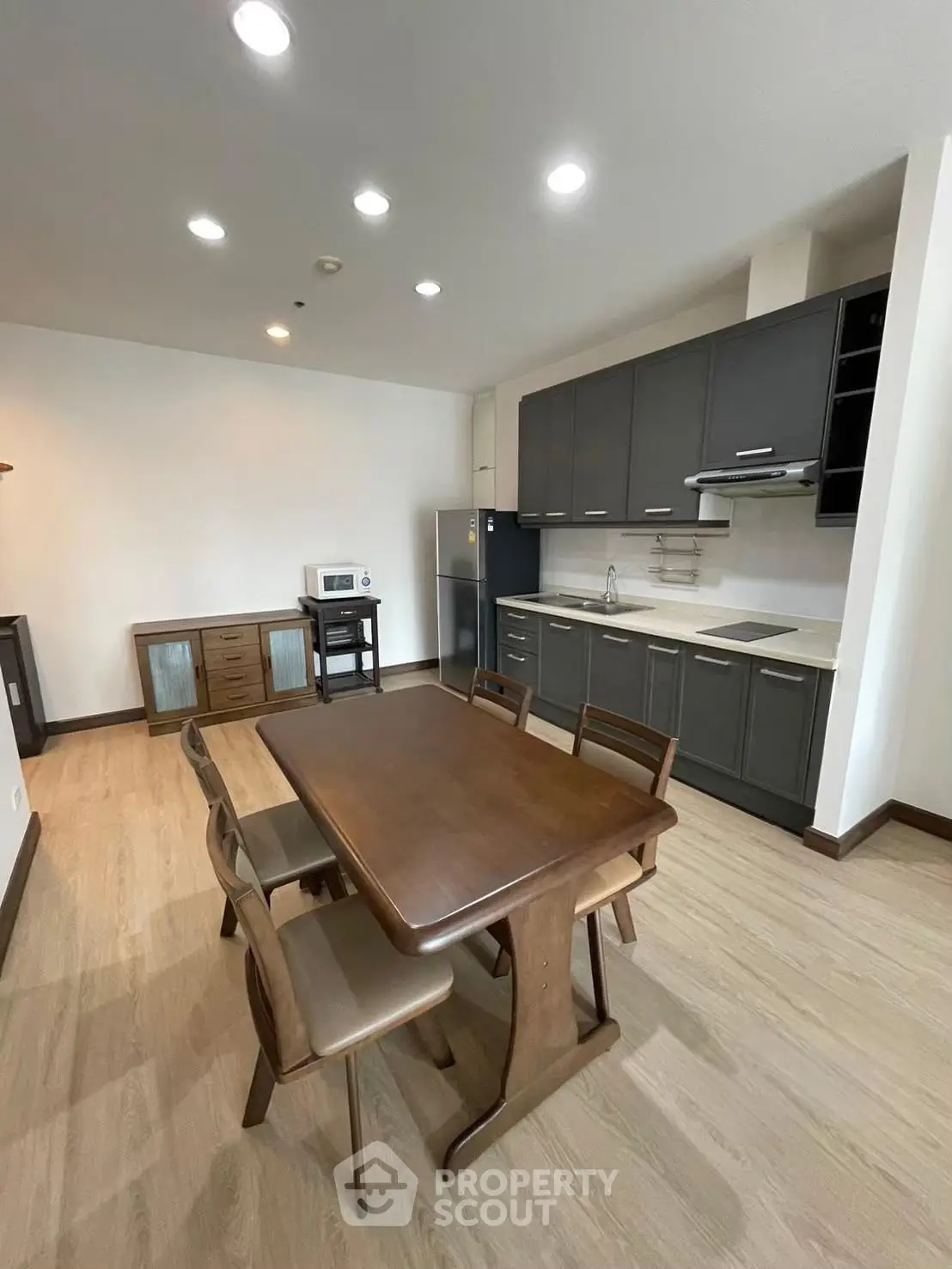 Spacious kitchen with modern appliances and elegant dining area in a stylish apartment.