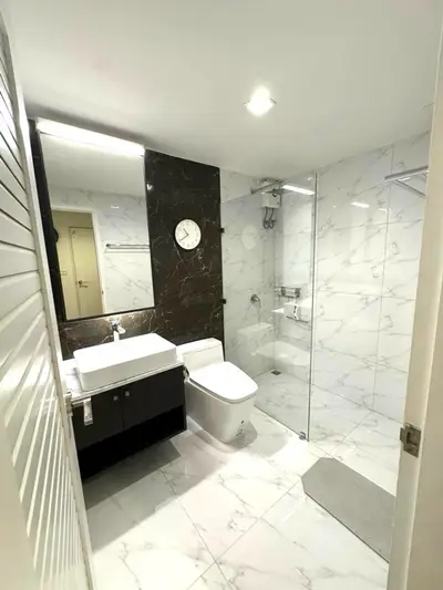 Modern bathroom with marble tiles and glass shower enclosure