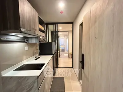 Modern kitchen with sleek design and open layout leading to living area