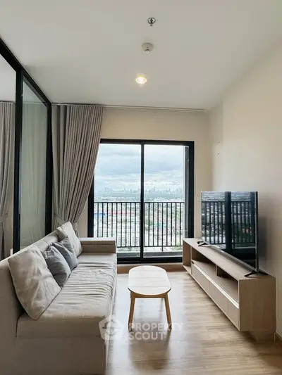 Modern living room with city view, featuring a cozy sofa and sleek TV setup.
