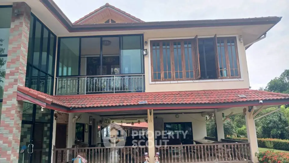 Stunning two-story house with large windows and spacious balcony, perfect for family living in a serene neighborhood.