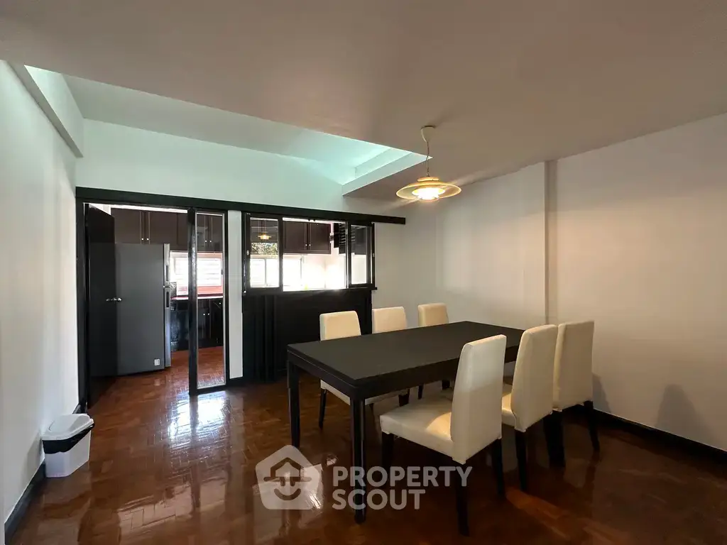 Spacious dining area with elegant table and chairs, featuring a modern open layout and sleek flooring.