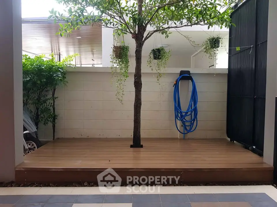 Charming garden patio with wooden deck and lush greenery, perfect for relaxation and outdoor gatherings.