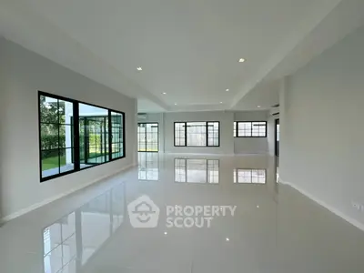 Spacious modern living room with large windows and glossy tile flooring