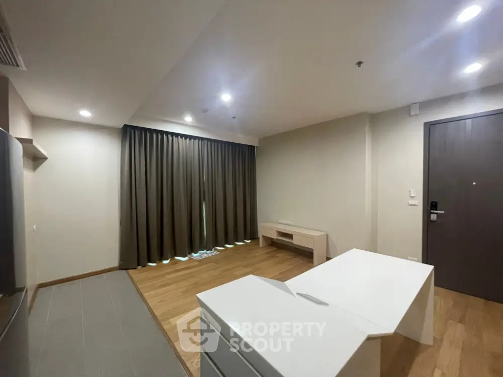 Spacious modern living room with wooden flooring and elegant curtains