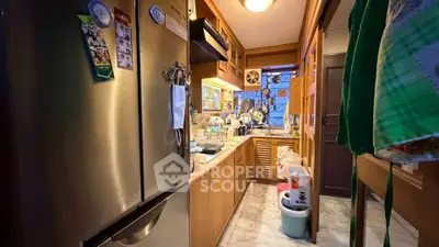 Cozy kitchen with wooden cabinets and modern appliances in a compact layout.