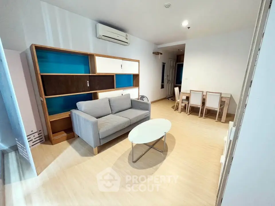 Spacious living room with modern furniture and stylish shelving in a bright apartment.