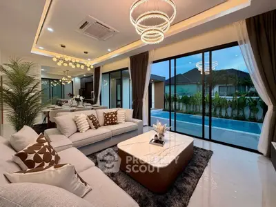 Luxurious living room with pool view, modern decor, and elegant lighting