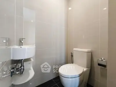 Modern minimalist bathroom with sleek fixtures and neutral tiles.