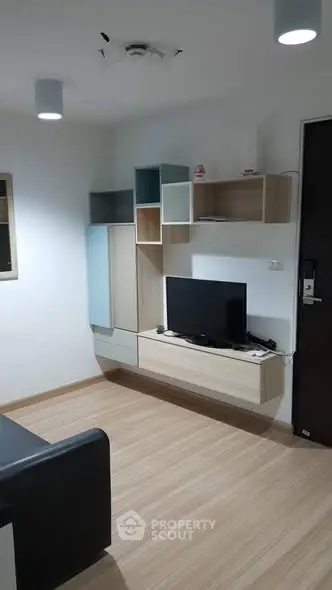 Modern living room with sleek wall-mounted TV and stylish shelving units.