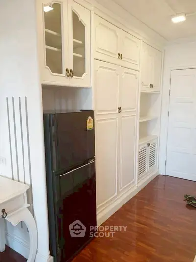 Elegant kitchen with white cabinetry and sleek black fridge