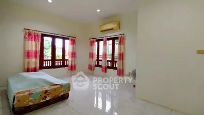 Spacious bedroom with large windows and air conditioning in a bright, airy home.