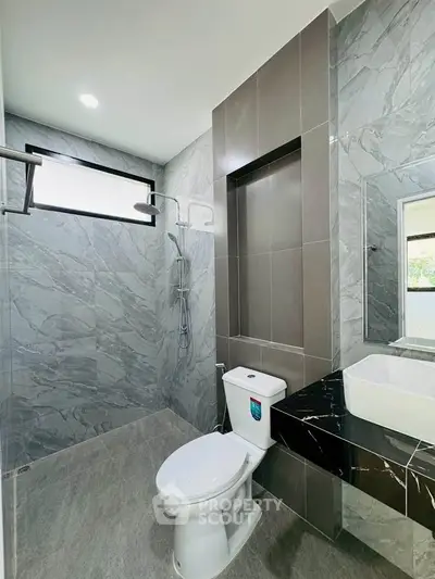 Modern bathroom with sleek design, featuring a stylish shower and elegant fixtures.