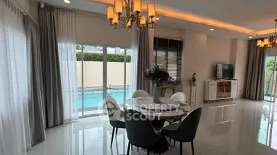 Luxurious dining area with pool view in modern home, featuring elegant lighting and stylish decor.