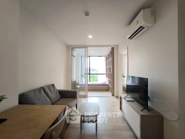 Modern living room with sofa, TV, and air conditioning in a bright apartment