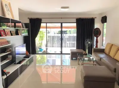 Spacious living room with modern decor and large sliding glass doors leading to a balcony.