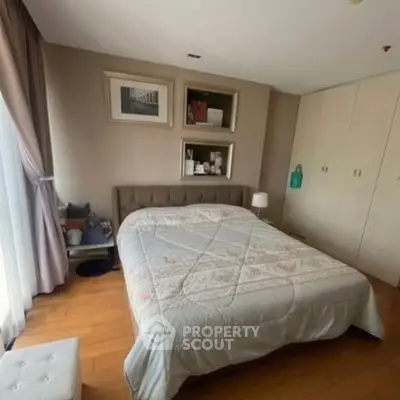 Cozy bedroom with elegant decor and ample natural light, featuring a comfortable bed and stylish furnishings.