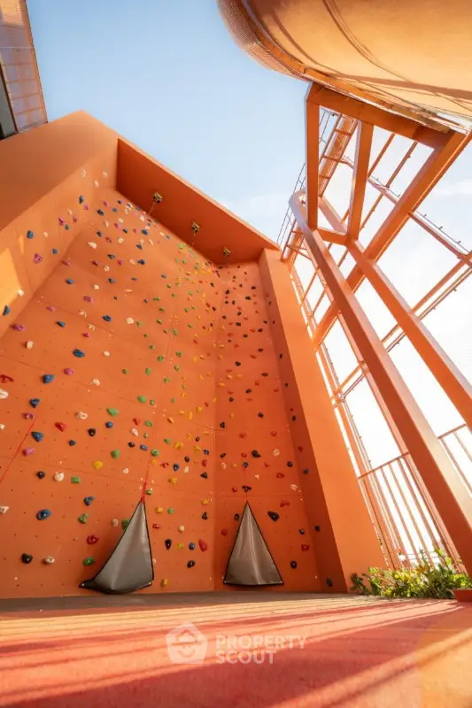 Modern building exterior with vibrant climbing wall and architectural design.