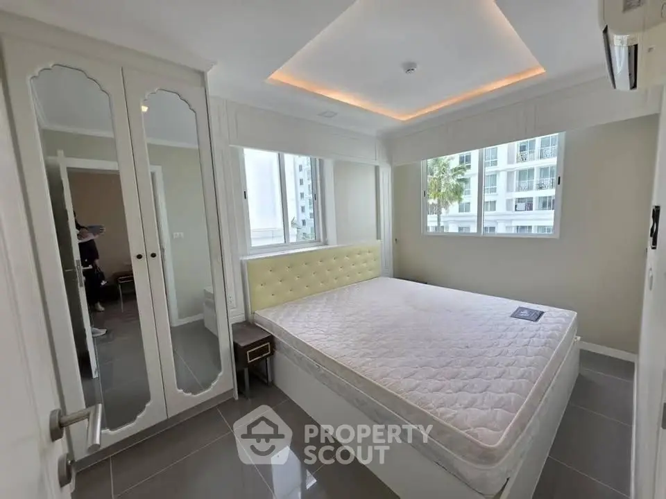 Modern bedroom with large windows and built-in wardrobe in a stylish apartment.