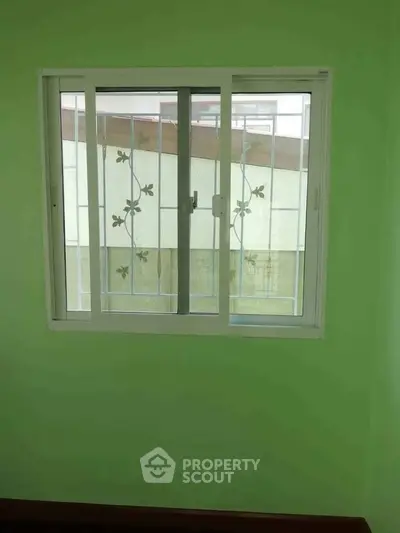 Bright room with a decorative window and green walls, perfect for natural light lovers.
