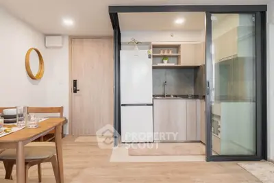 Modern open-layout kitchen with dining area and sliding glass door, featuring sleek appliances and wooden finishes.