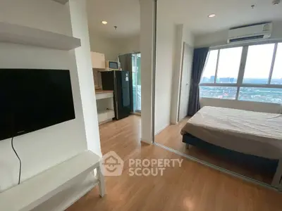 Modern apartment interior with bedroom and living area, featuring large windows and wooden flooring.