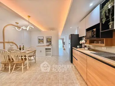 Modern open kitchen and dining area with stylish lighting and wooden cabinetry