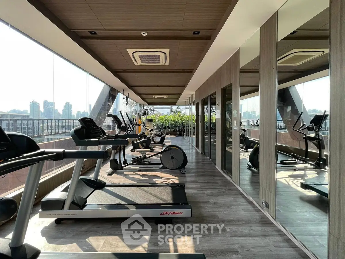 Luxurious rooftop gym with panoramic city views and modern fitness equipment.