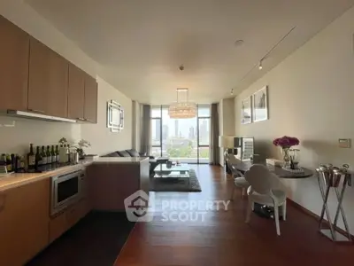 Modern living room with open kitchen and stunning city view, featuring elegant decor and natural light.