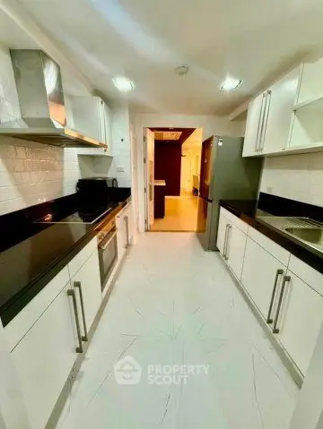 Modern kitchen with sleek black countertops and stainless steel appliances in a spacious layout.