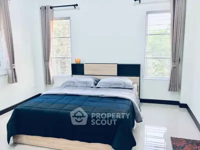 Spacious bedroom with modern decor and large windows for natural light