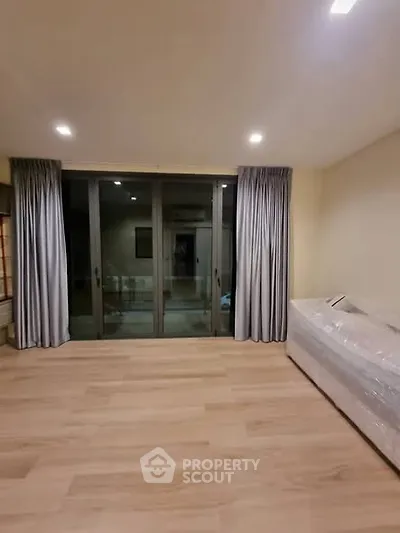 Spacious living room with large windows and elegant curtains