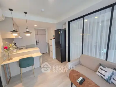 Modern open-layout kitchen and living area with stylish decor and natural light.