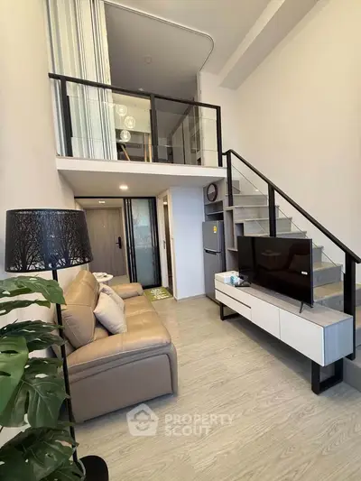 Modern loft apartment with stylish living room and mezzanine, featuring sleek furniture and contemporary design.
