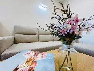 Elegant living room with stylish beige sofa and floral decor, creating a cozy and inviting atmosphere.