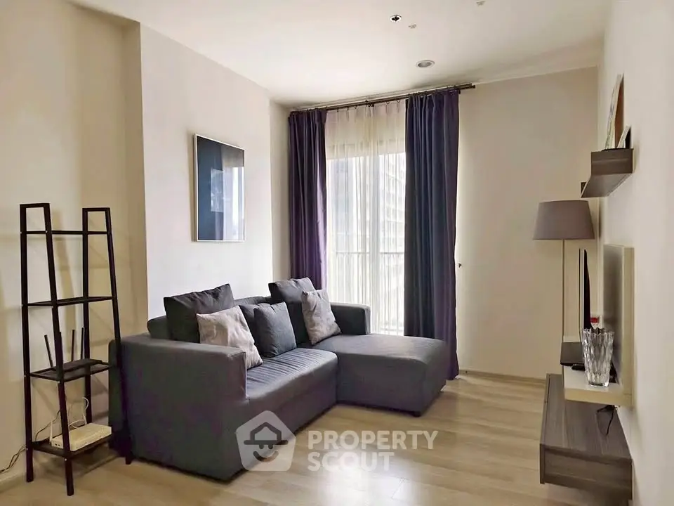 Modern living room with stylish gray sofa and floor-to-ceiling window, perfect for urban living.