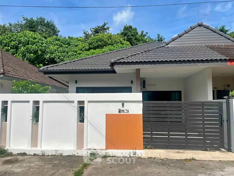 Charming single-story house with modern design and lush greenery, perfect for serene living.