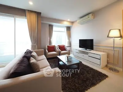 Elegant living room with modern furniture and large windows offering natural light.