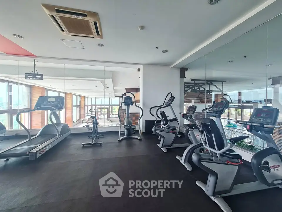 Modern gym with state-of-the-art fitness equipment and panoramic city views.