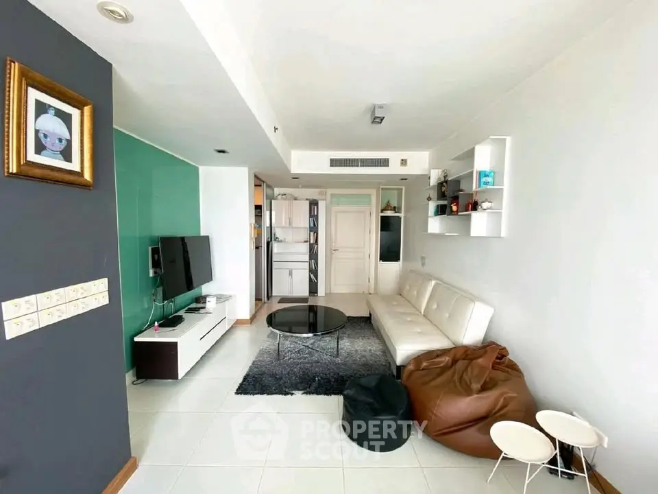 Modern living room with stylish decor, white sofa, and wall-mounted TV in a contemporary apartment.