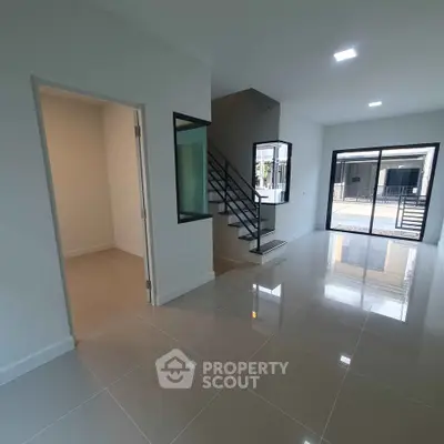 Spacious modern living room with glossy tile flooring and large windows for natural light.