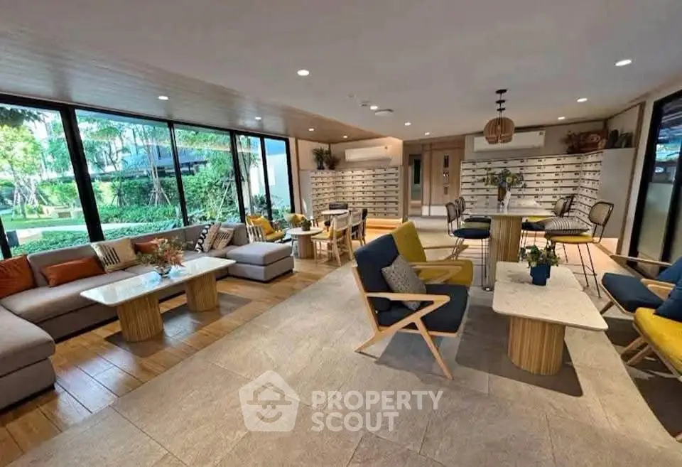 Spacious modern living room with large windows and stylish furniture, offering a serene garden view.